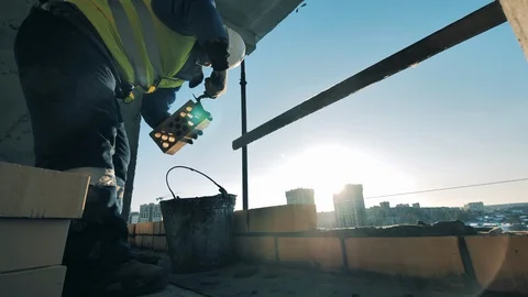 Construction worker at a construction site. Bricklaying is being carried out by Stock-Footage 128303587