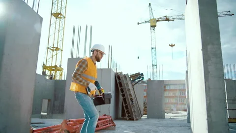 Construction worker at construction site dancing with boxtool and screwdriver Video stock 258672067