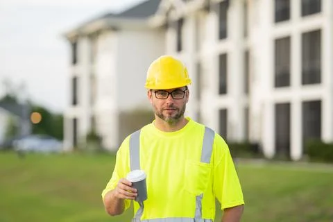 A construction worker at a construction site drinks coffee during a break Stock Photos