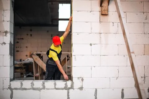 Construction worker at construction site measures the length of window openin Stock-Fotos