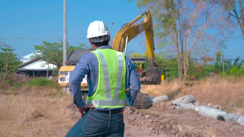 Construction worker controls digging of trench with excavator on site. Stock Footage 231796270