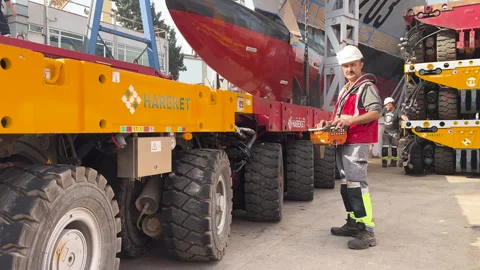 A construction worker controls a hydraulic transport system Stock Footage 304380517