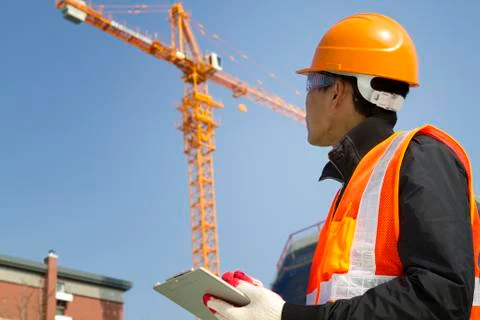 Construction worker with crane in background Stock Photos