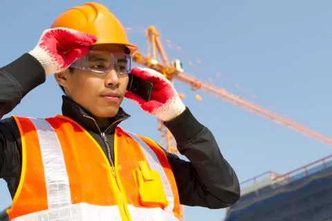 Construction worker with crane in background Stock Photos