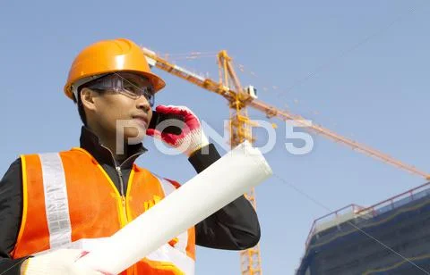 Construction worker with crane in background Stock Photos
