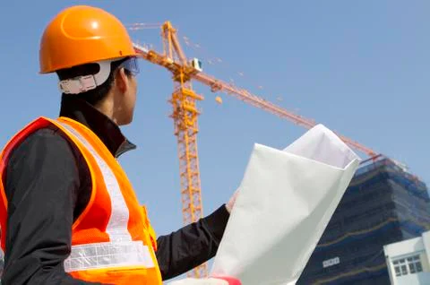 Construction worker with crane in background Stock Photos
