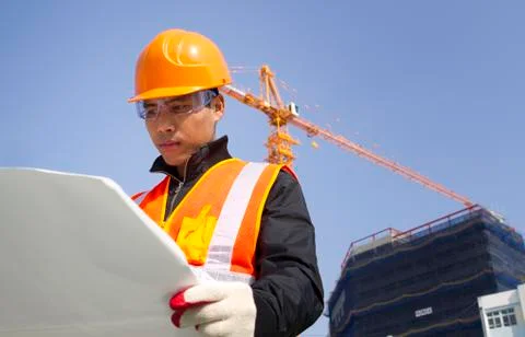 Construction worker with crane in background Stock Photos