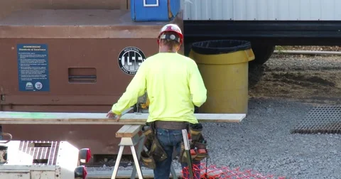 Construction Worker Cuts Board - 4k Stock Footage 53891408