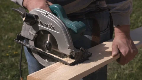 Construction worker cuts boards with circular saw Stock Footage 99890236