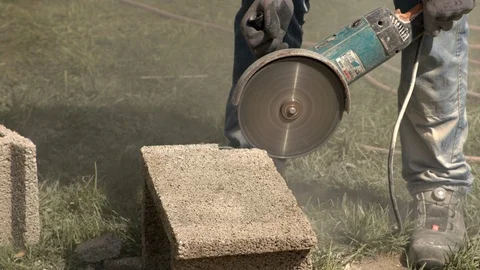 Construction worker cuts concrete tile with cutting disc Stock Footage 99888283