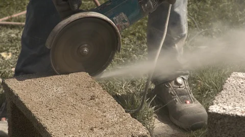 Construction worker cuts concrete tile with cutting disc 動画素材 99889626