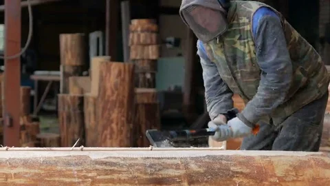 Construction worker cuts a groove in the tree for a future home. Protective mask Stock Footage 69078890