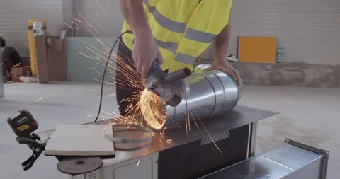 A construction worker cuts a metal with an angular grinder. Stock Footage 127104201