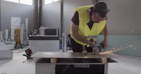 A construction worker cuts a metal with an angular grinder. Stock Footage 127171483