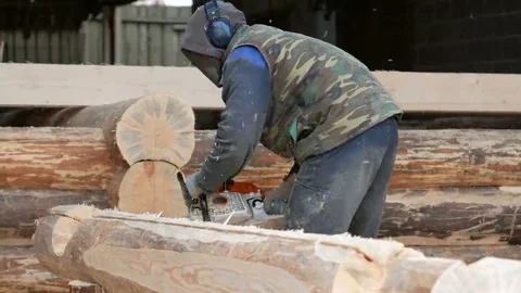 Construction worker cuts wood chainsaw for future home. Protective mask and Stock Footage 69074410
