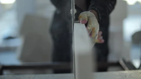 Construction worker cutting aerated concrete block with electric saw Stock Footage 318780011