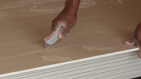 Construction worker cutting ceiling board with stanley blade. Video stock 139087412