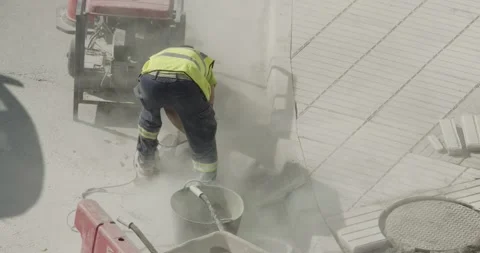 Construction worker cutting a cement tile on street Видео 141149505