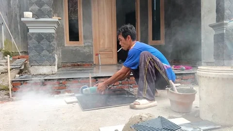 Construction worker cutting ceramic tile with angle grinder machine outdoors Stock Footage 335018925