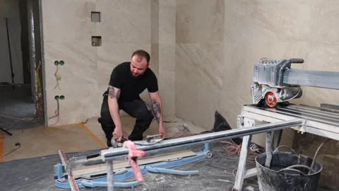 Construction worker cutting ceramic tile using manual tile cutter Stock Footage 345681275