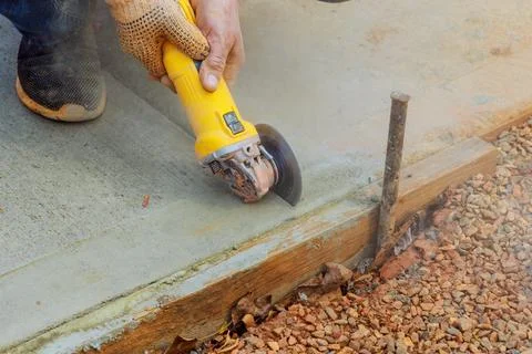 Construction worker is cutting concrete after foundation it has been poured Foto stock