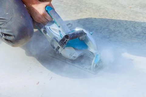 Construction worker cutting concrete foundation after pouring using cutting Stockfoto's