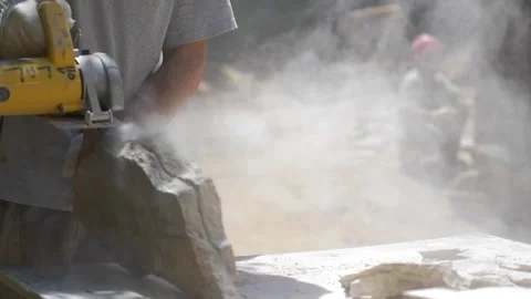 Construction worker cutting decorative stone to be placed on a wall Stock Footage 255684415
