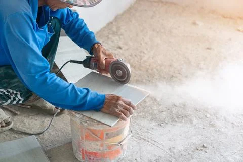 Construction worker cutting floor tiles forbuilding. Stock Photos