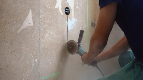 Construction worker cutting a groove in a concrete wall with an angle grinder Stock Footage 331719385