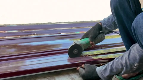 Construction worker cutting metal roof sheet with angle grinder Stock Footage 342092045