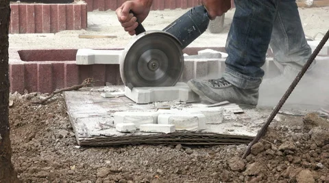Construction worker cutting pavement stone with an angle grinder 4K with audio Stock Footage 68163550