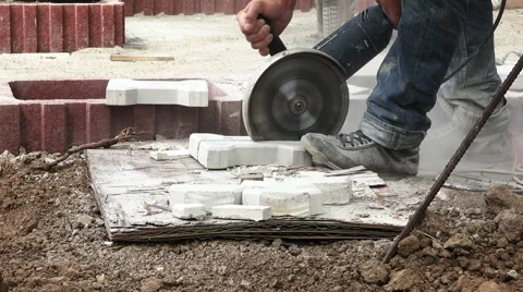 Construction worker cutting pavement stone with a heavy duty angle grinder 4K Stock Footage 68163746