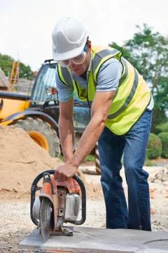 Construction worker cutting stone with circular saw Stock Photos