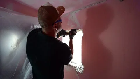 Construction worker cutting a window hole with an angle grinder Video stock 347640690