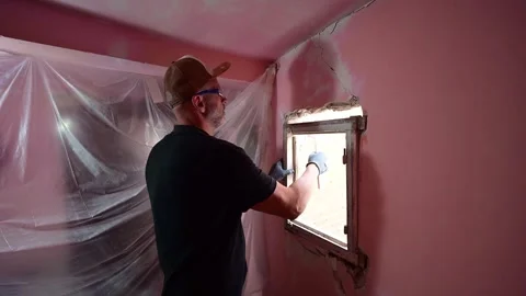 Construction worker demolishing an old window frame during home renovation Video stock 347640579