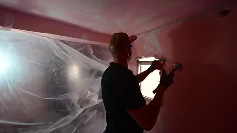 Construction worker demolishing a plaster wall with a hammer Video stock 347640605