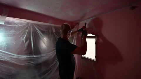 Construction worker demolishing a wall with a hammer during room renovation Video stock 347640735