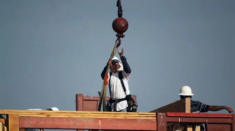 Construction worker detaching a load from the hook of the crane Stock Footage 34582554