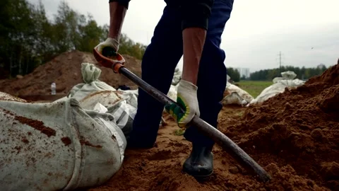 Construction worker digging ground and loading to bags, details view, labor on Vidéo 254496591