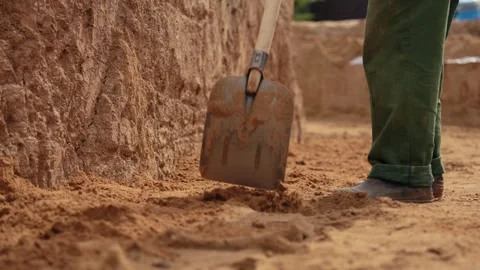 Construction worker digging sand with a shovel Stock Footage 341294841