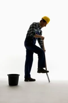 A construction worker digging with a shovel Stock Photos