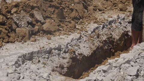 Construction worker digging a trench with a shovel at roadwork site Stock Footage 343419982