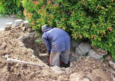 Construction worker digging trench using shovel, hole for wall foundation o.. Stock Photos