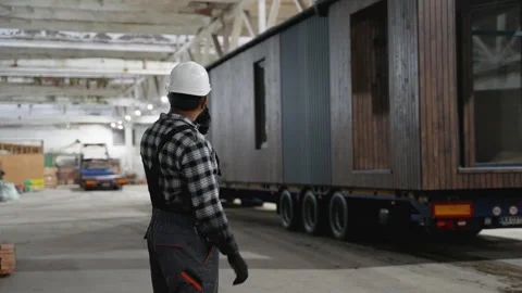 Construction worker directing modular home transportation process Stock Footage 301824567