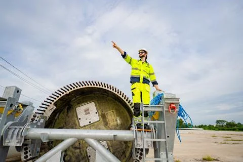Construction worker directs operations from a large machinery platform at a.. Stock Photos