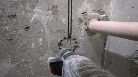 Construction worker drilling a concrete wall with a rotary hammer drill 動画素材 304119624