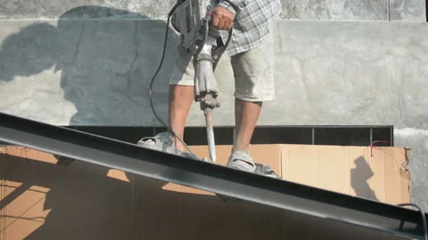 The construction worker is drilling the floor. Construction technicians use elec Stock Footage 238909419