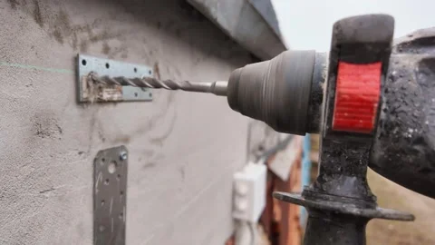 Construction worker drilling hole into concrete wall 動画素材 336639077