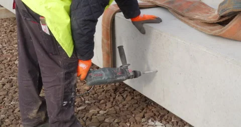 Construction worker drilling into a structural column on a building site 库存影片 313834398