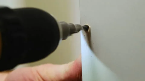 Construction worker drills hole at designated spot on panel Stock Footage 304403348